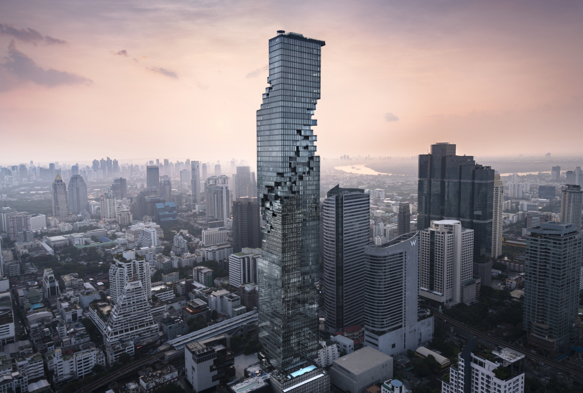 曼谷 MahaNakhon 引入一條環繞的立體像素條帶打開建築，與周邊城市脈絡和都市街景相連接。（ © Wison Tungthunya ）
